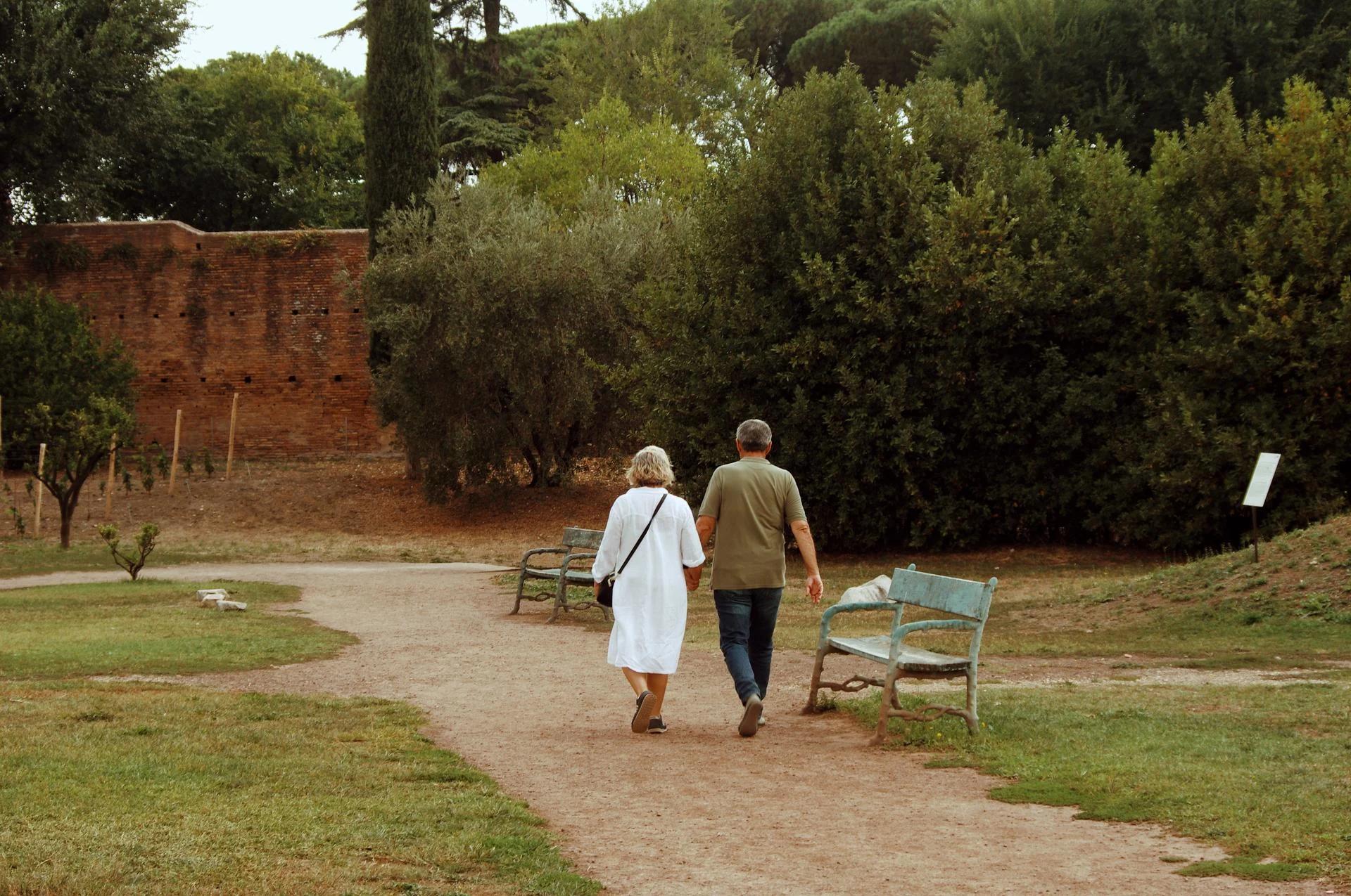 Gammelt par på spadseretur i en park