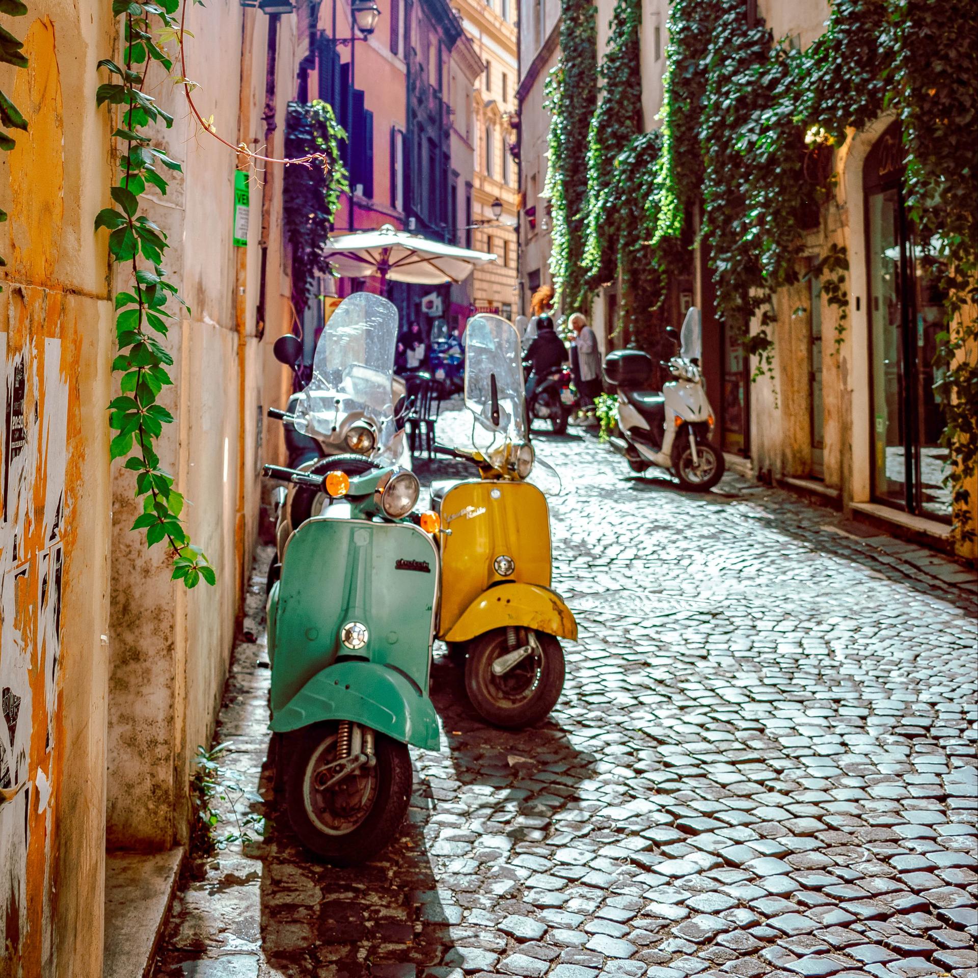Et par Vespaer parkeret på en gade i Italien